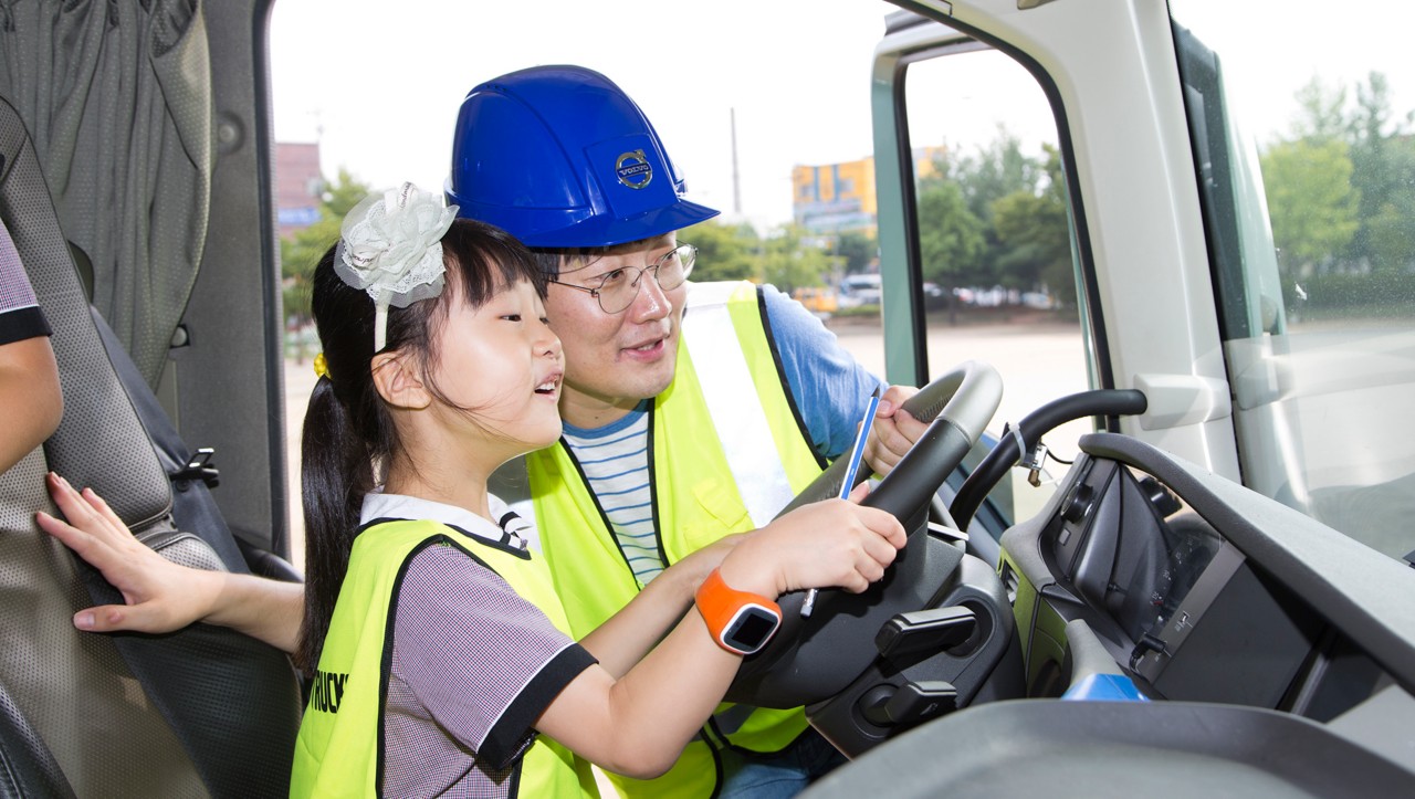 Bir adam ve bir çocuk, bir kamyonun sürücü koltuğunda oturuyor